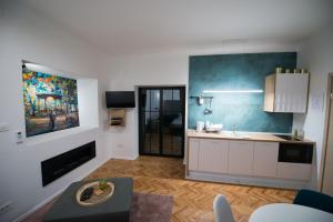 a kitchen with white cabinets and a blue wall at City Apartments Green Oasis in Zagreb