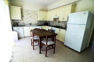 a kitchen with a table and a white refrigerator at Xylophagou Experience 1 in Xylophaghou