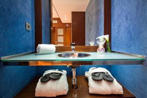 uma casa de banho com lavatório, espelho e toalhas em Acta Atrium Palace em Barcelona