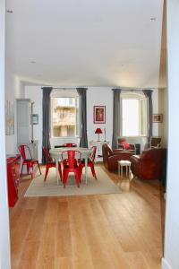 a living room with a table and red chairs at LE CONFIDENTIEL by Cocoonr in Bordeaux