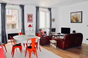 a living room with red chairs and a table at LE CONFIDENTIEL by Cocoonr in Bordeaux