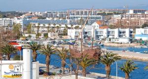 a city with a harbor with palm trees and buildings at "A Casa dos Avôs" Suites & Breakfast in Lagos