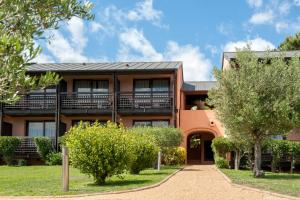 an exterior view of a building with trees at Hôtel Castell'Verde in Porto-Vecchio