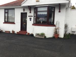 a white house with a window with flowers in it at Ingleneuk Bed and Breakfast in Edinburgh
