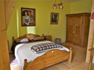 ストラスブールにあるシャンブル ドテ ラ セレスティンの木製ベッド付きのベッドルーム1室、壁に絵画が飾られています。
