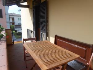 une table et des chaises en bois sur un balcon dans l'établissement Casa vacanze Orsi, à Lucques
