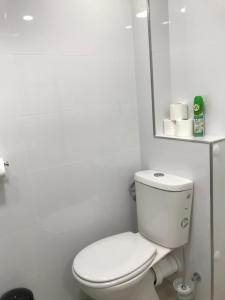 La salle de bains blanche est pourvue de toilettes et d'un miroir. dans l'établissement Vacation Apartment, à Eilat