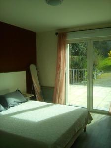 een slaapkamer met een bed en een glazen schuifdeur bij Auberge Pen Mur in Muzillac