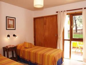 1 dormitorio con 1 cama y puerta corredera de cristal en Cabañas Entreverdes en Villa Gesell
