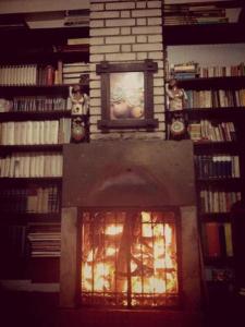 a fireplace in a library filled with books at Hospedaje Del Pilar en Magdalena del Mar in Lima