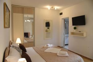 Zimmer mit einem Bett und einem Wohnzimmer mit einem TV in der Unterkunft Apartments & Rooms Jelka in Kotor