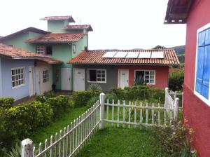 a white fence in front of a house at Pousada Tabuleiro Eco in Conceição do Mato Dentro