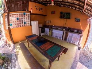 einen Blick über die Küche mit einem Tisch und einer Bank in der Unterkunft Biergarten Suites in Abraão