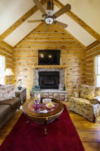 a living room with a fireplace and a ceiling fan at Pillow and Paddock B&B in La Grange
