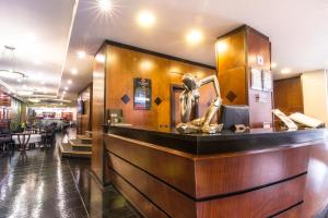 a lobby with a bar with a statue on it at GHL Hotel Abadia Plaza in Pereira