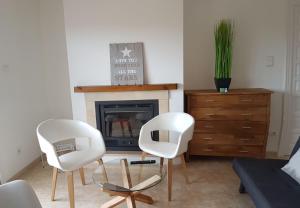 デニアにあるLa Vela Polideportivo-Turistikaのリビングルーム(白い椅子2脚、暖炉付)