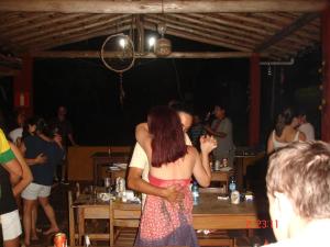 Una mujer con un vestido de pie en una fiesta. en Pousada Tabuleiro Eco, en Conceição do Mato Dentro