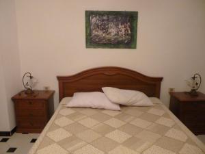 a bedroom with a bed with two nightstands and a painting at Il rifugio di Andrea in Giba