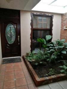 una puerta delantera de una casa con una planta en Casa familiar La Arboleda, en Guatemala