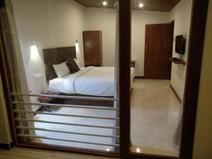 a view of a bedroom with a bed and a mirror at Olives Pleasant Stays in Ooty