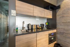 a kitchen with wooden cabinets and a sink at CMG - Suite Premium Tour Eiffel - 31 in Paris