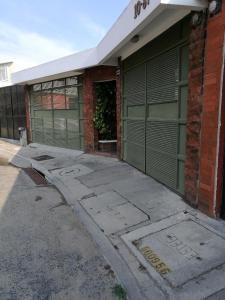 an empty building with a green garage door at Casa familiar La Arboleda in Guatemala
