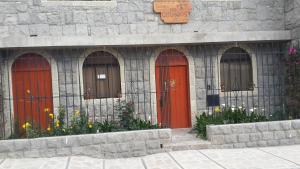 YanqueLos Geranios的前方有红色门和鲜花的建筑