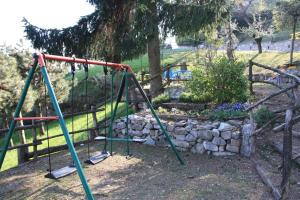 a swing set in a park with a rock wall at Ca Vecia in Gargnano