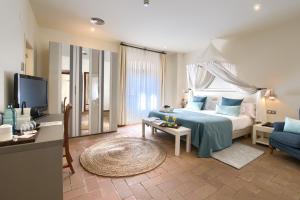 - une chambre avec un lit, une télévision et un canapé dans l'établissement Hotel Convent de Begur, à Begur