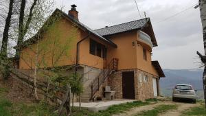 a house with a car parked in front of it at Holiday Home Cakic in Novi Travnik