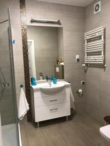 a bathroom with a white sink and a shower at Apartament Venezia in Kołobrzeg