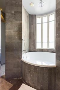 a bathroom with a tub and a window at CMG - Suite Premium Tour Eiffel - 61 in Paris