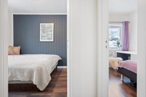 een slaapkamer met een bed en een blauwe muur bij Modern apartment Tromsø in Tromsø