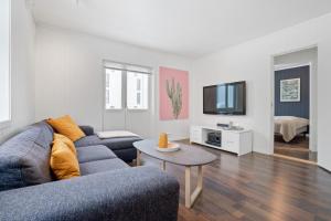 a living room with a blue couch and a tv at Modern apartment Tromsø in Tromsø