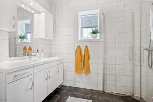 een witte badkamer met douche en wastafel bij Modern apartment Tromsø in Tromsø +10 foto's
