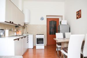 プラハにあるCharming apartment close to Old town&metroのキッチン(白い家電製品、赤いドア付)