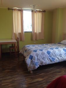 1 dormitorio con cama, escritorio y ventana en Los Geranios, en Yanque