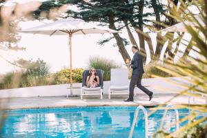 een man en een vrouw in stoelen naast een zwembad bij The Atlantic Hotel - Small Luxury Hotels of the World in St Brelade +59 foto's
