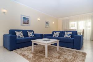 ein Wohnzimmer mit 2 blauen Sofas und einem Tisch in der Unterkunft Vila Marachique Torralvor in Alvor