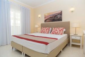 1 dormitorio con 1 cama grande con 2 lámparas y 2 mesas en Vila Marachique Torralvor, en Alvor