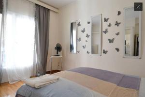 1 dormitorio con 1 cama con mariposas en la pared en The White House, en Atenas