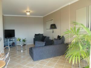 een woonkamer met een bank en een tv bij Oceanic Apartment in Caniço
