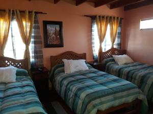 Ліжко або ліжка в номері Hostal Casa Amarilla San Vicente de Tagua Tagua