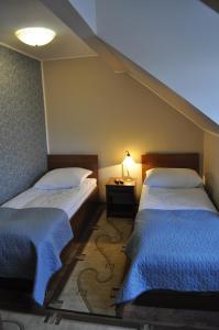 1 dormitorio con 2 camas y una lámpara en el suelo en Dworek Biała Dama, en Nieborów