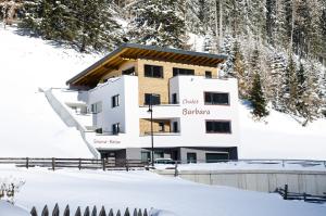 a building in the snow with trees at Chalet Barbara in Ischgl
