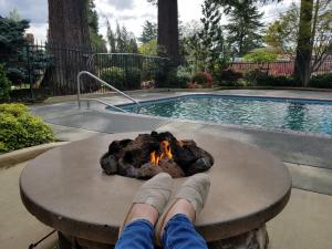 a person laying on a table next to a fire at Redwood Hyperion Suites in Grants Pass +4 photos