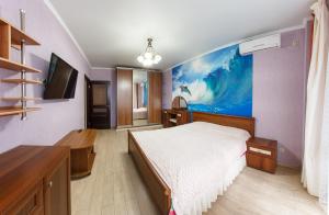 アナパにあるApartment on Tamanskaya 24のベッドルーム1室(ベッド1台付)が備わります。壁には絵画が飾られています。