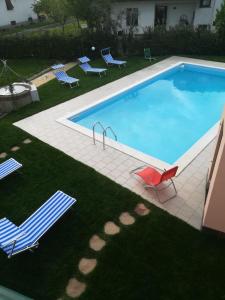 una gran piscina con sillas y césped con en Villa Franco, en Orentano