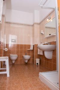uma casa de banho com 2 WC, um lavatório e um espelho. em Villa Fenice Bed & Breakfast em Vieste
