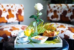 a coffee table with a tray of food and a flower at Savoy Hotel Boutique in Las Terrenas